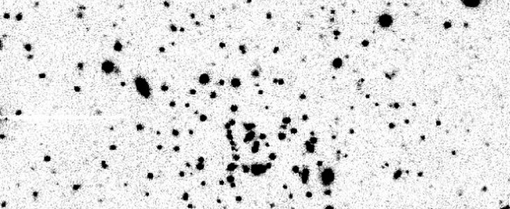 Far from home: wayward cluster is both tiny and distant